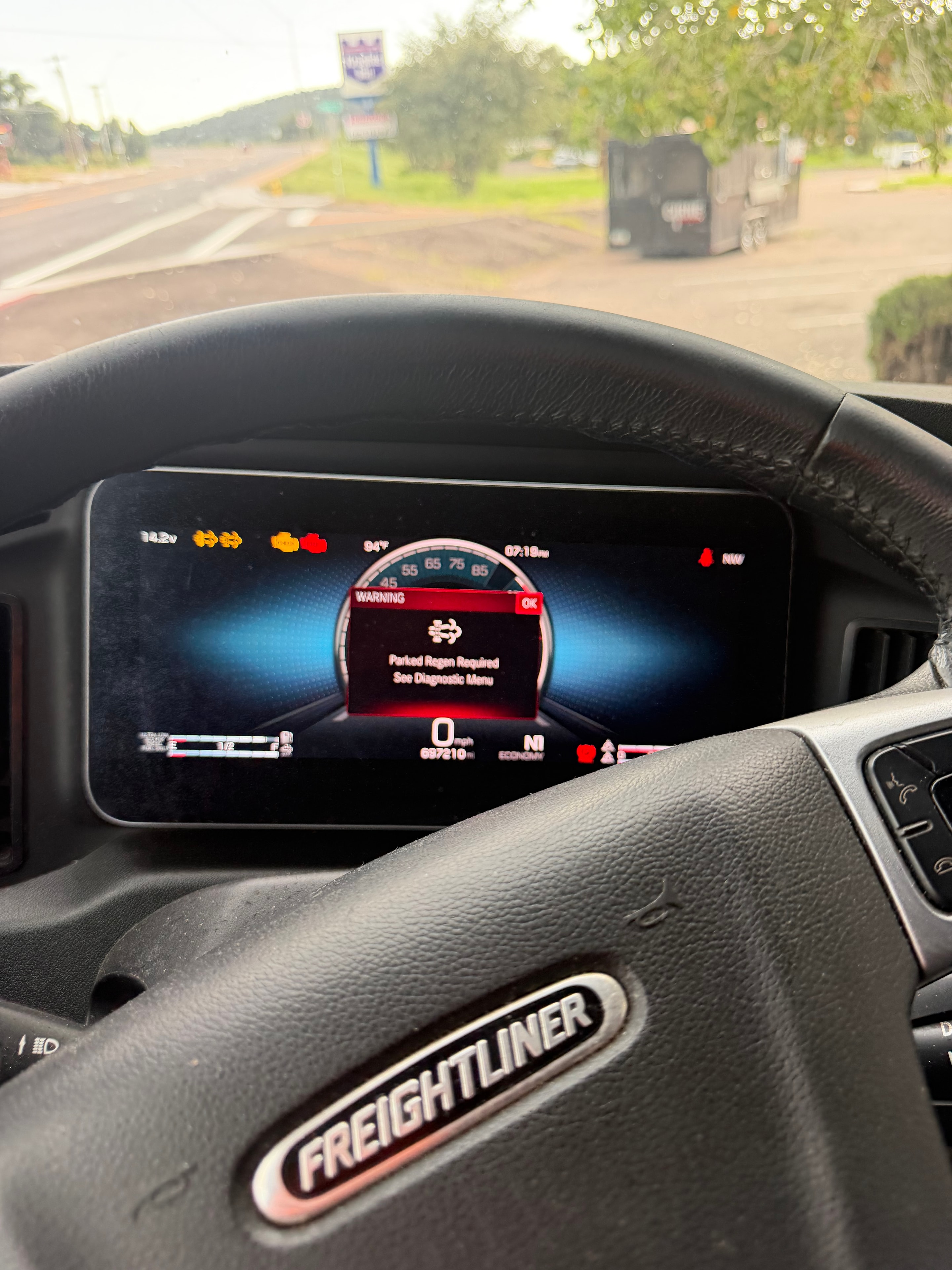 Freightliner Cascadia dashboard in derate mode showing Parked Regen Required warning and DPF fault lights — semi truck stuck in engine derate near Phoenix AZ requiring mobile DPF mechanic