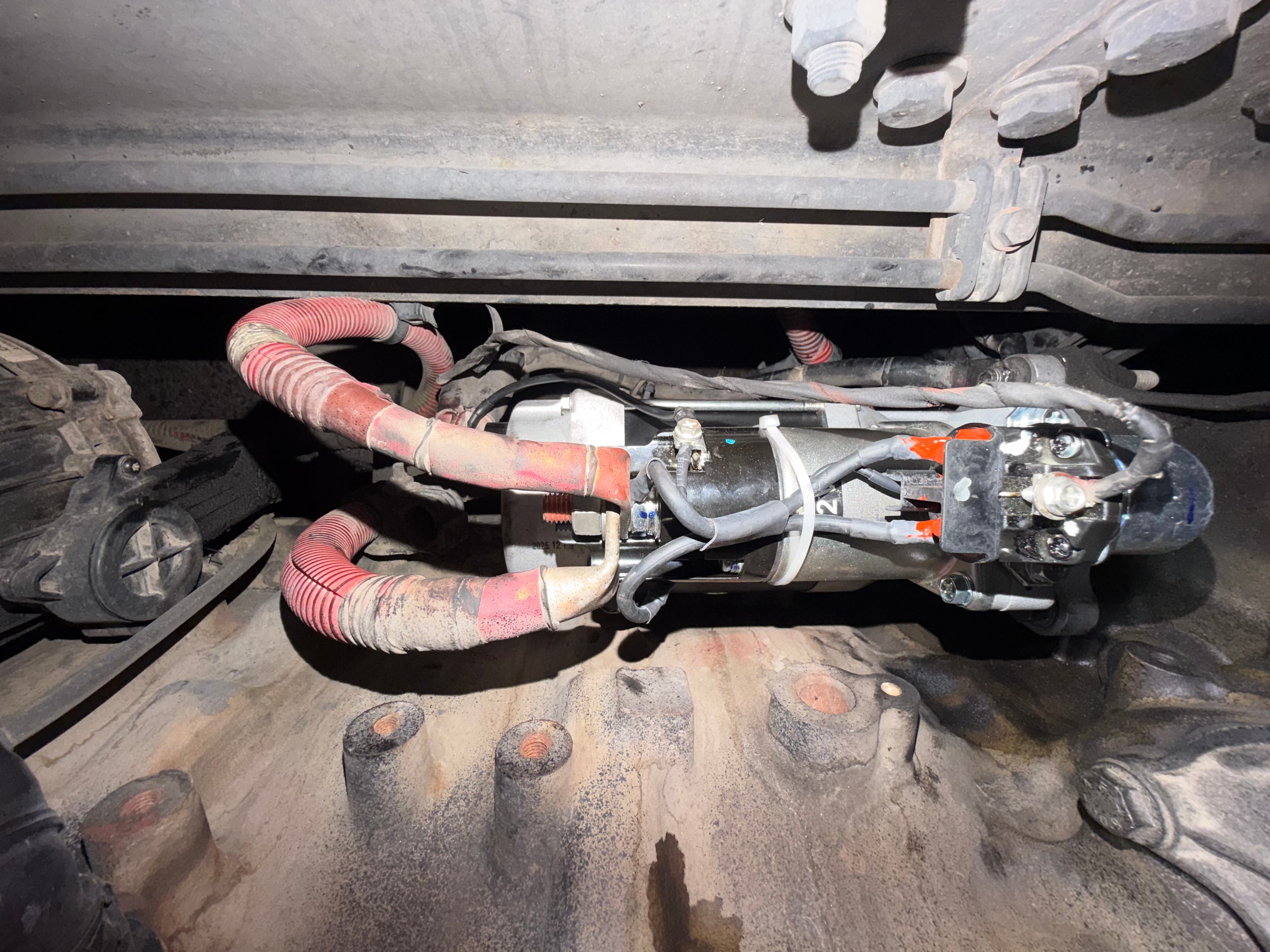 New starter motor installed on Freightliner Cascadia semi truck — completed mobile starter replacement with fresh wiring connections during roadside repair in Mesa AZ