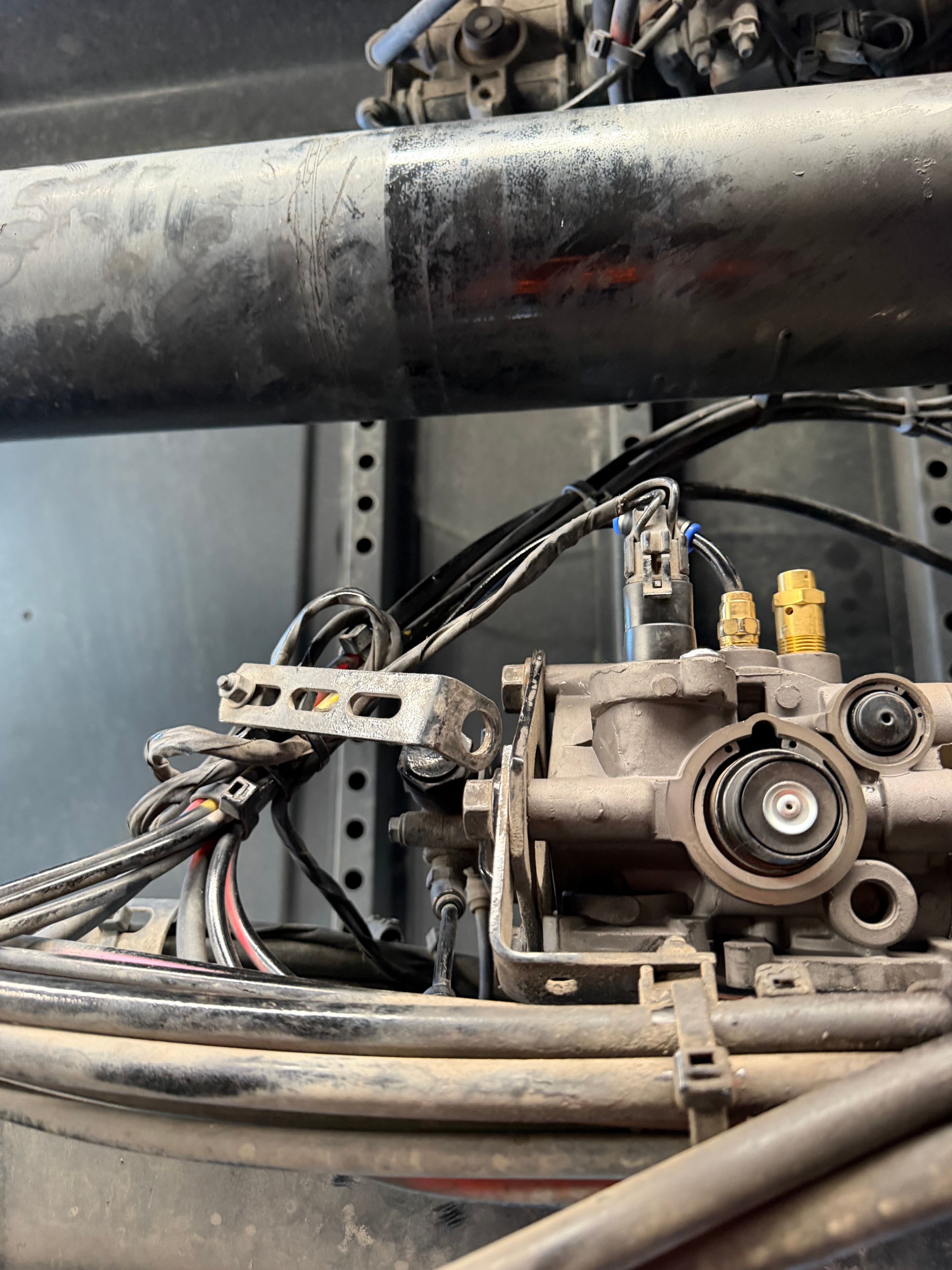 RoadWrench mobile truck and trailer mechanic repairing broken pressure sensor and leaking air line on Volvo VNL semi truck air dryer — roadside air brake system repair near Glendale AZ